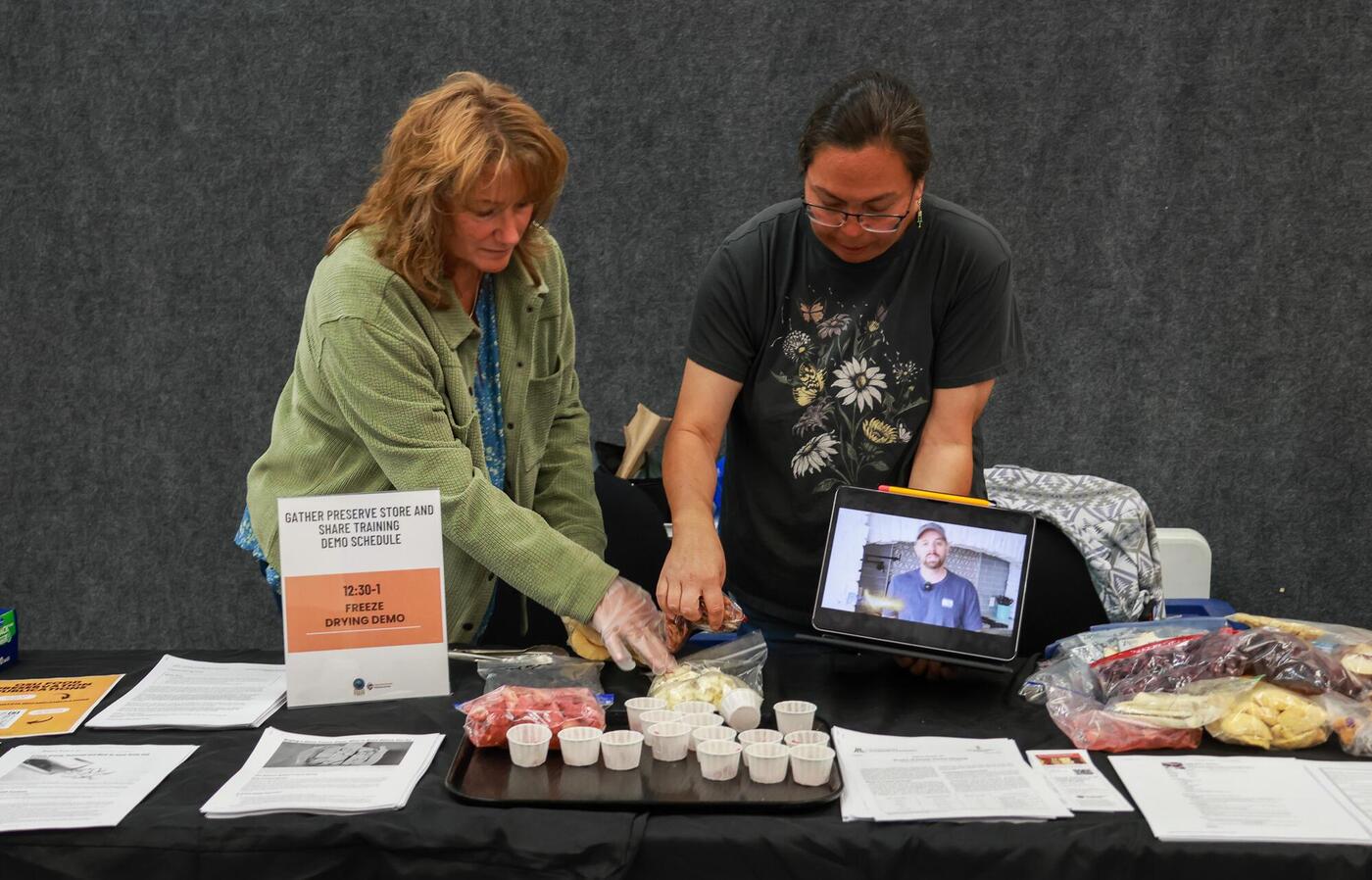 GPSS community educators DeAnne Norton and Francene Ambrose sort freeze-dried fruits into small cups for the audience to try at the demonstration.